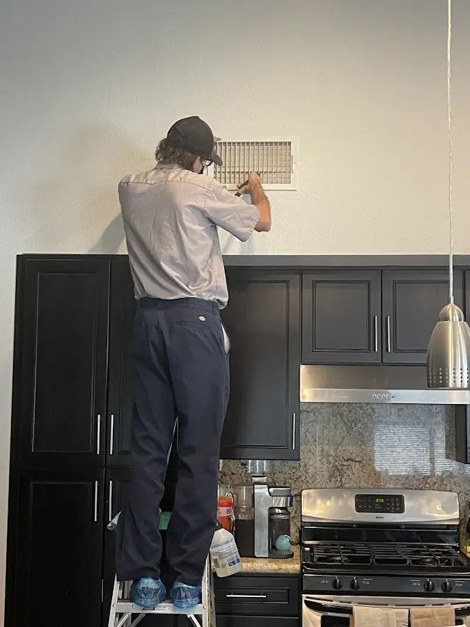 Technician inspecting an air vent during HVAC service in Cayce